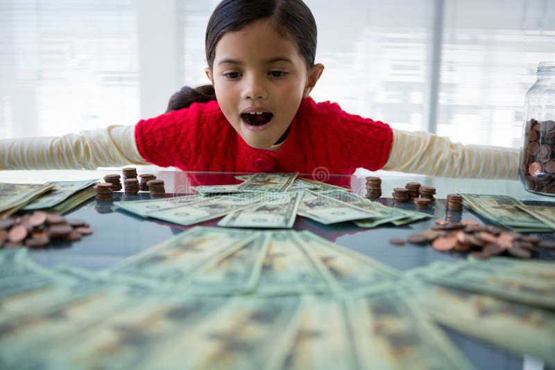 Girl looking at currency at desk in office