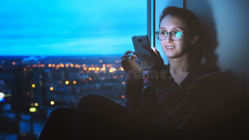 Girl Looking at Smartphone on City Background