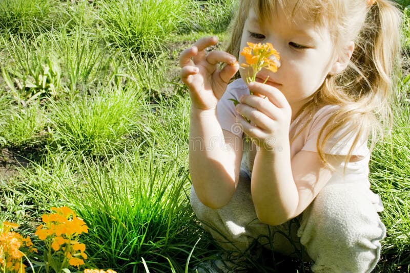 Girl looks at a flower