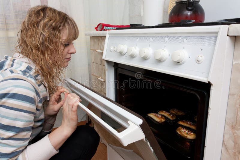 Girl looks in an oven