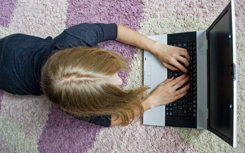 Girl lying on the floor and using her notebook