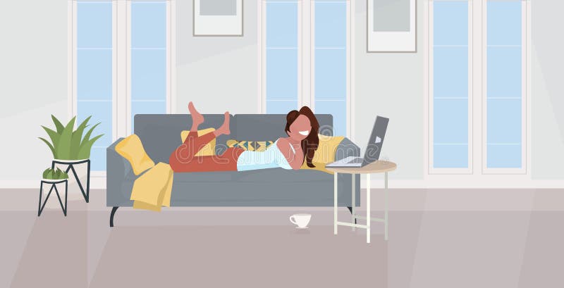 Girl lying on sofa using laptop happy woman relaxing at home modern living room interior horizontal full length flat