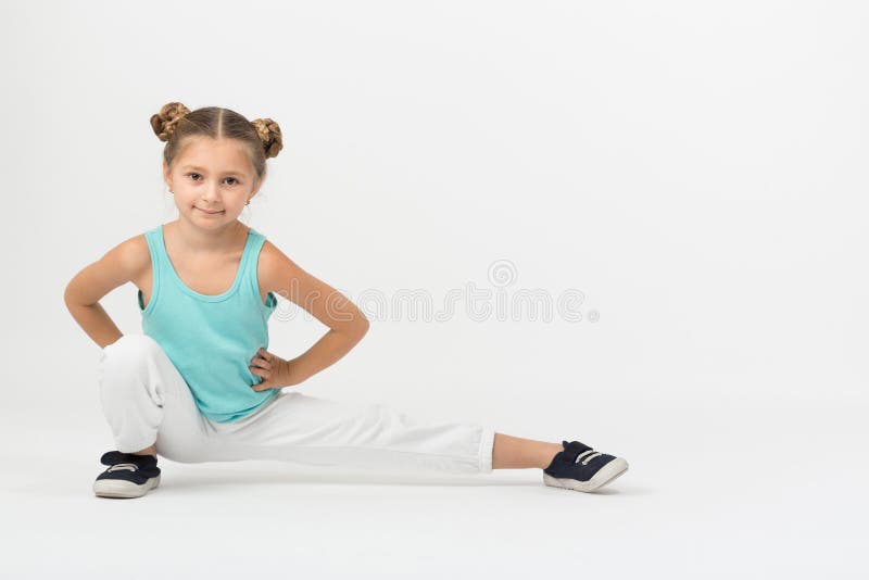 A girl makes gymnastic exercise sitting