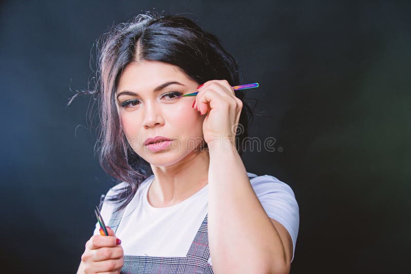 Girl makeup face hold tweezer for eyelash extension. Beauty shop concept. Professional eyelash extension tweezer. Makeup royalty free stock image Girl makeup face hold tweezer for eyelash extension. Beauty shop concept. Professional eyelash extension tweezer. Makeup royalty free stock image
