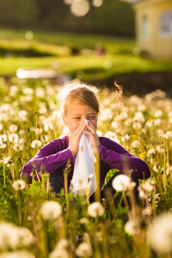 Girl in meadow and has hay fever or allergy