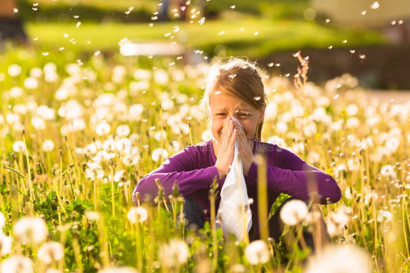 Girl in meadow and has hay fever or allergy