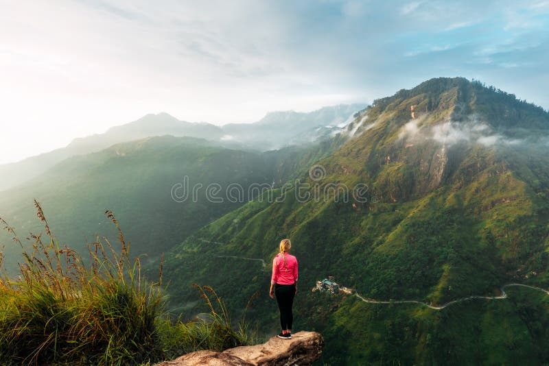 Girl meets sunrise in the mountains. Girl traveling to Sri Lanka. Mountain sports. Athlete happy finish. Mountain tourism royalty free stock photo Girl meets sunrise in the mountains. Girl traveling to Sri Lanka. Mountain sports. Athlete happy finish. Mountain tourism royalty free stock photo