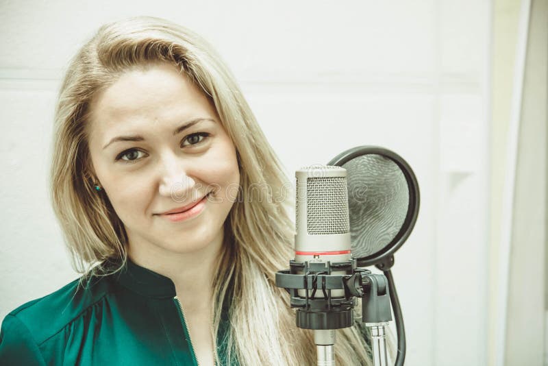 The girl at the microphone in the Studio stock photos The girl at the microphone in the Studio stock photos