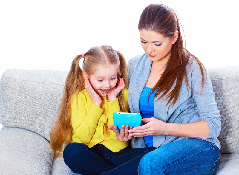 Girl with mother sitting on sofa using tablet royalty free stock photography Girl with mother sitting on sofa using tablet royalty free stock photography