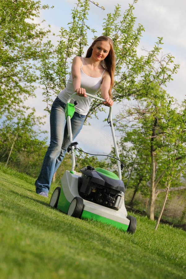 Girl mows the lawn. 