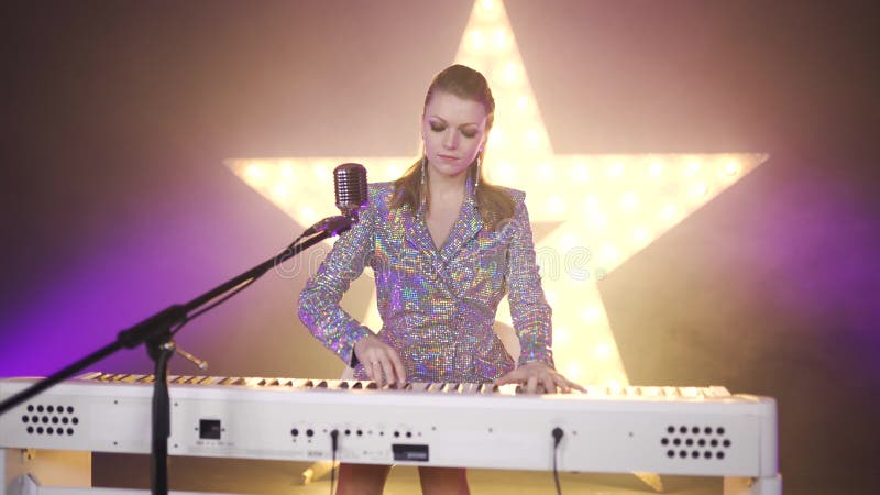 Girl musician pianist plays perform concert on digital piano. Woman piano music teacher shows how to play notes. Sings