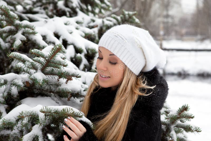 Girl near the Christmas tree in snow