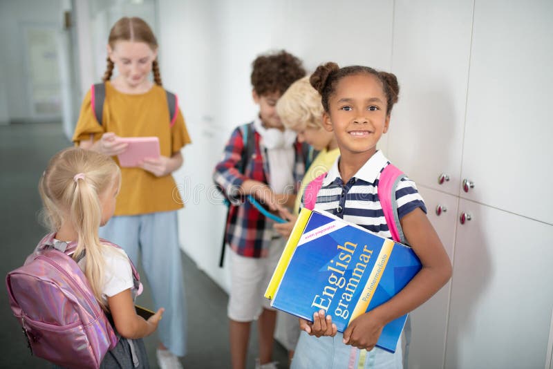 Dark-skinned Girl with English Grammar Book Standing Near Friends Stock ...