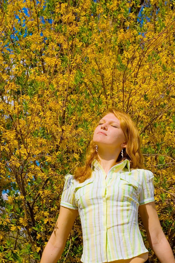 Girl near yellow flowers tree