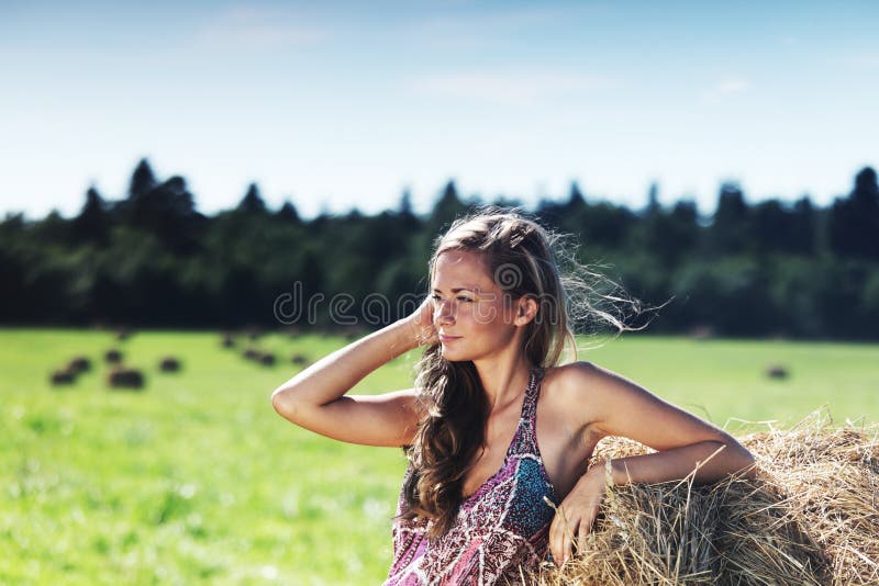 Girl next to a stack of hay