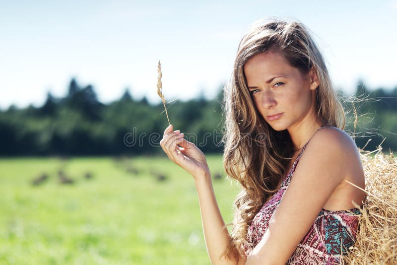 Girl next to a stack of hay