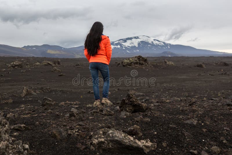 Girl in an orange jacket stands on a stone royalty free stock photos Girl in an orange jacket stands on a stone royalty free stock photos