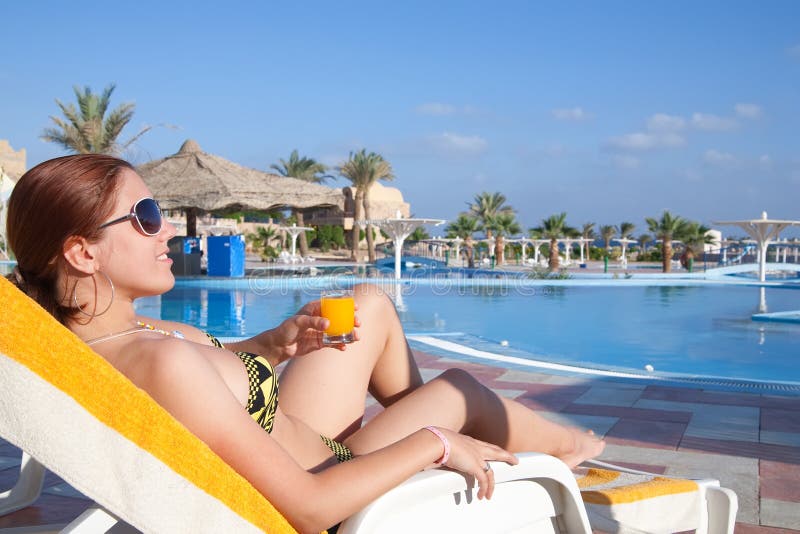 Girl with orange juice at resort hotel