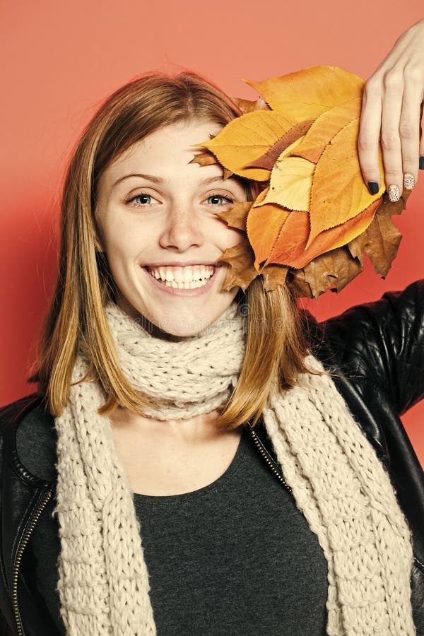 Girl with orange leaves on orange background.