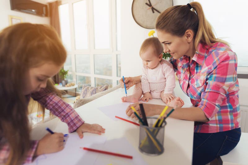 Young Mom Helping Baby with Pencil stock image.