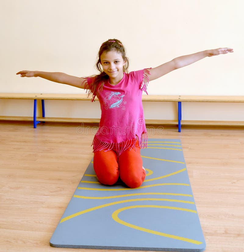 The Girl Performs an Exercise on a Gymnastics Mat in the Gym Stock Image Image of education