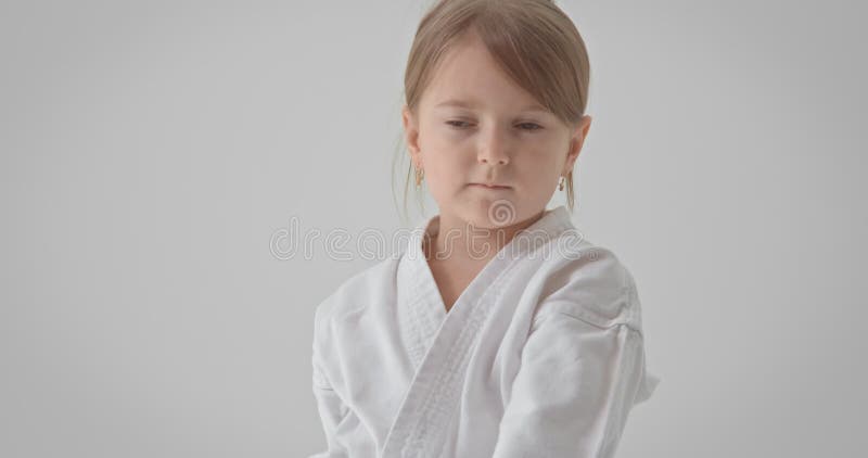 The girl performs exercises for coordination. The child puts his hand to his ear half turn.