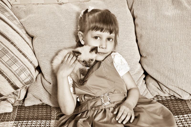 Girl petting a kitten stock images