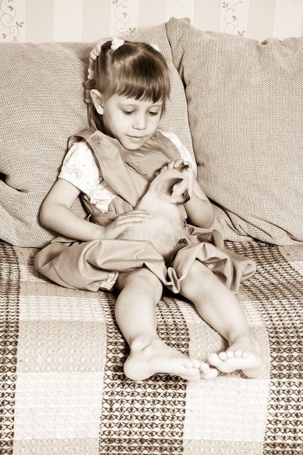 Girl petting a kitten stock image