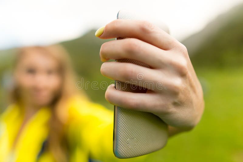 A girl with a phone in her hand outdoors royalty free stock photography A girl with a phone in her hand outdoors royalty free stock photography