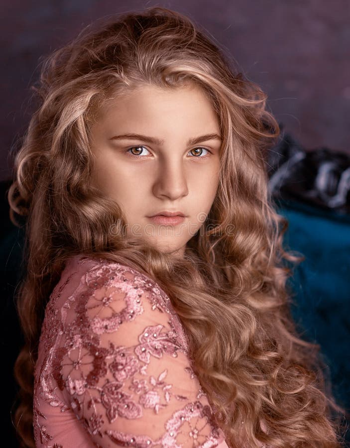 A Girl In A Pink Dress With Large Flowers On Her Head Looks At The Camera Stock Image Image 