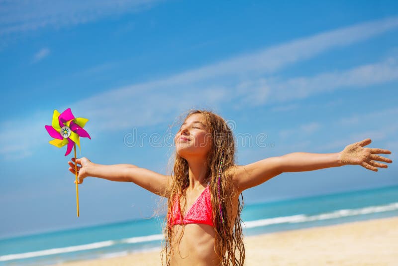 Girl with pinwheel on the beach happy and relaxed stock photography Girl with pinwheel on the beach happy and relaxed stock photography