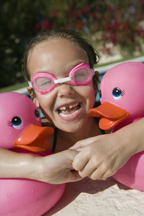 Girl With Plastic Ducks Relaxing On The Edge Of Pool royalty free stock image