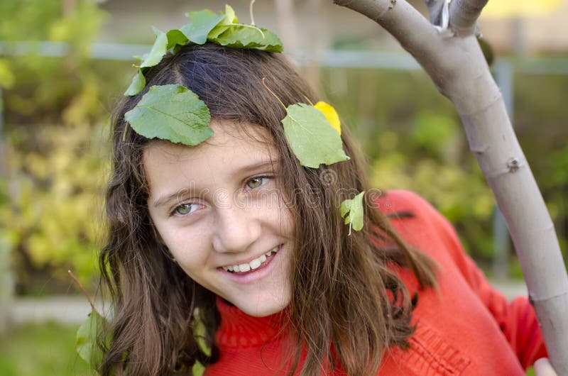 Portrait of happy little cute girl is playing hide and seek in the park. Portrait of happy little cute girl is playing hide and seek in the park