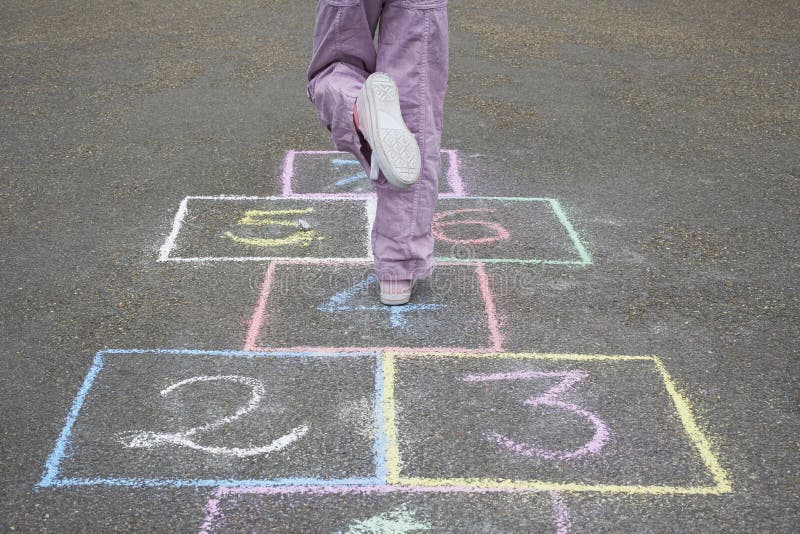 Fata care joacă hopscotch la locul de joacă stock photography