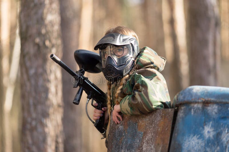 Girl Playing Paintball in Overalls with a Gun. Stock Image Image of