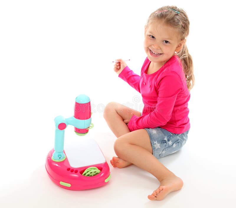 Girl playing with a toy projector stock photo