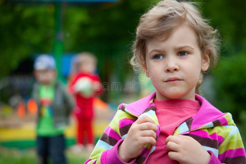 The serious girl plays in a court yard in kindergarten. Button clasp stock images, royalty-free photos and pictures