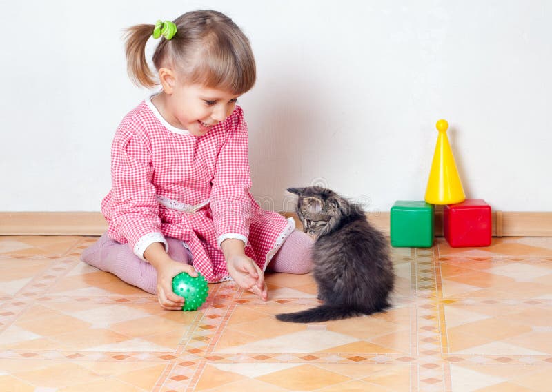 The girl plays with a kitten royalty free stock image