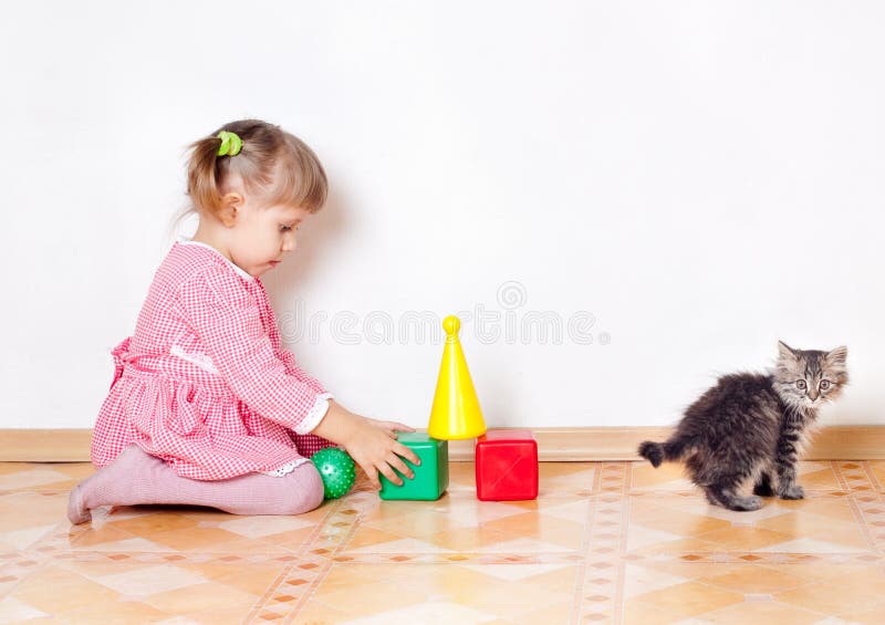 The girl plays with a kitten stock images