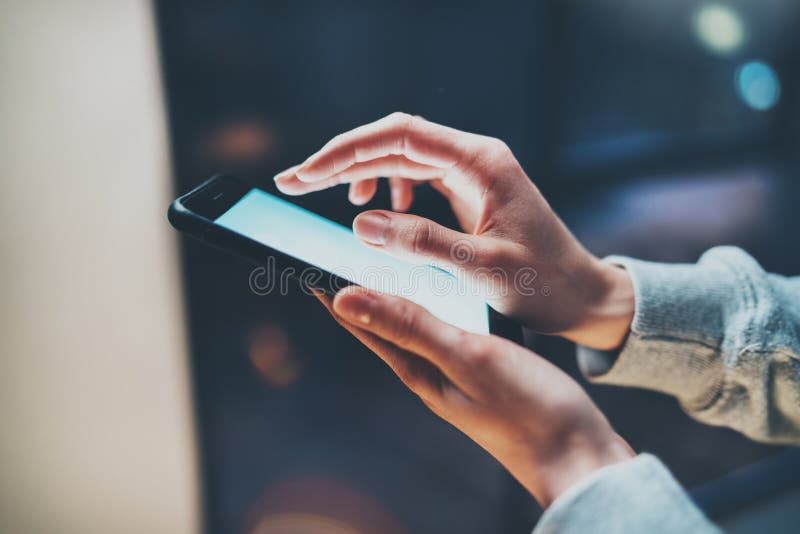 Girl pointing finger on screen smartphone on background illumination glow bokeh light in night atmospheric.Horizontal stock photos Girl pointing finger on screen smartphone on background illumination glow bokeh light in night atmospheric.Horizontal stock photos