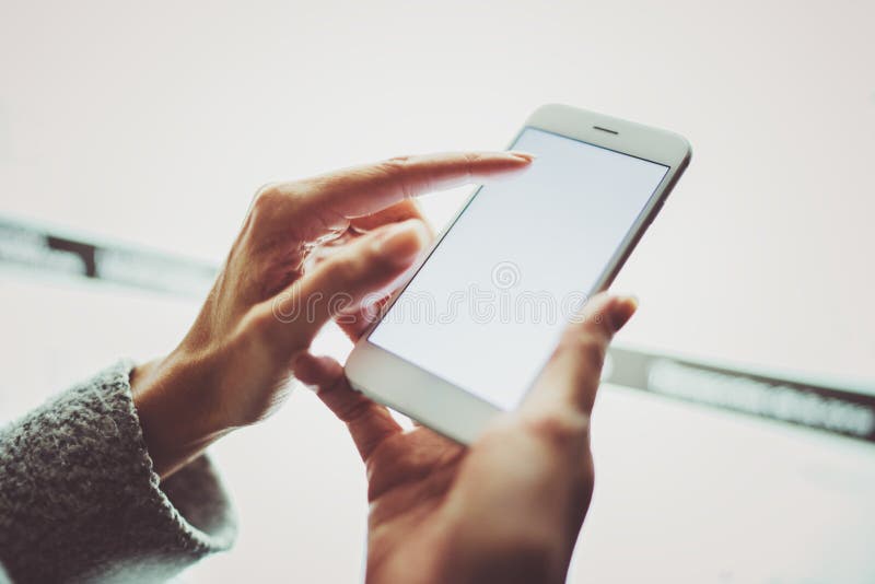 Girl pointing finger on screen smartphone.Female hands texting message mobile phone.Closeup on blurred light coloured royalty free stock images Girl pointing finger on screen smartphone.Female hands texting message mobile phone.Closeup on blurred light coloured royalty free stock images