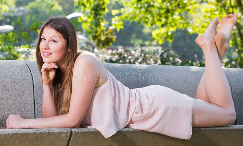 Girl is posing playfully on bench in her free time