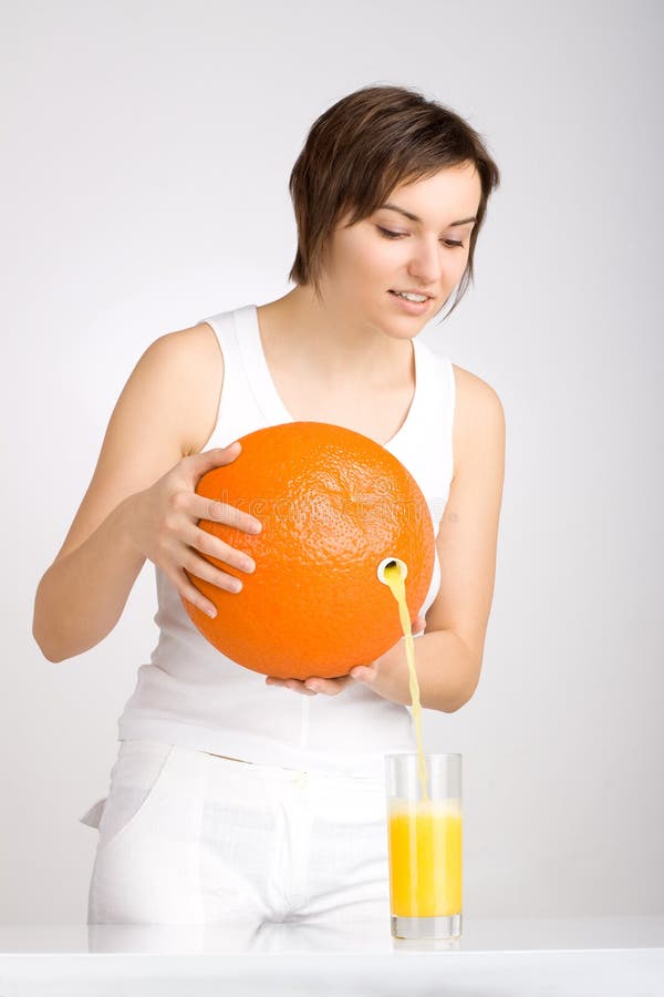 Girl pouring juice from giant orange