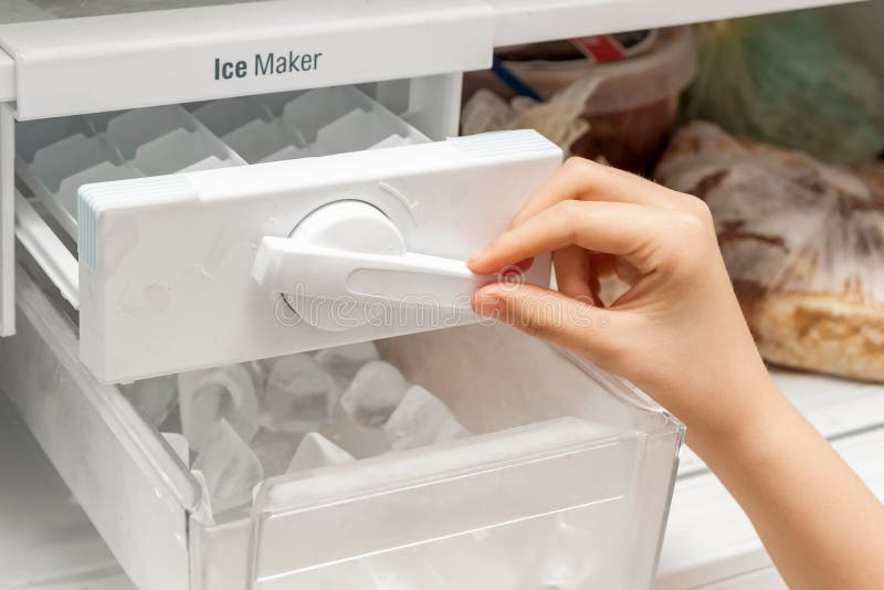 Ice cube maker in modern freezer with no-frost, houseold concept