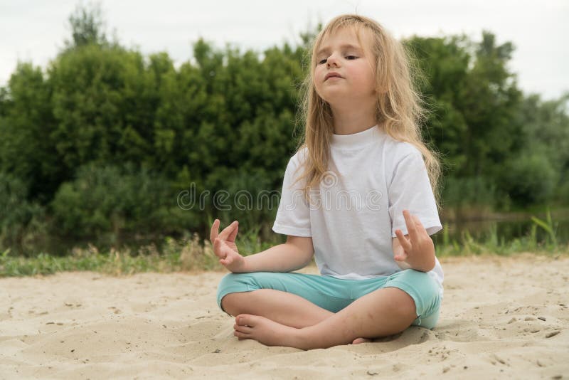 Girl practicing yoga on the beach. Toned image stock photo Girl practicing yoga on the beach. Toned image stock photo