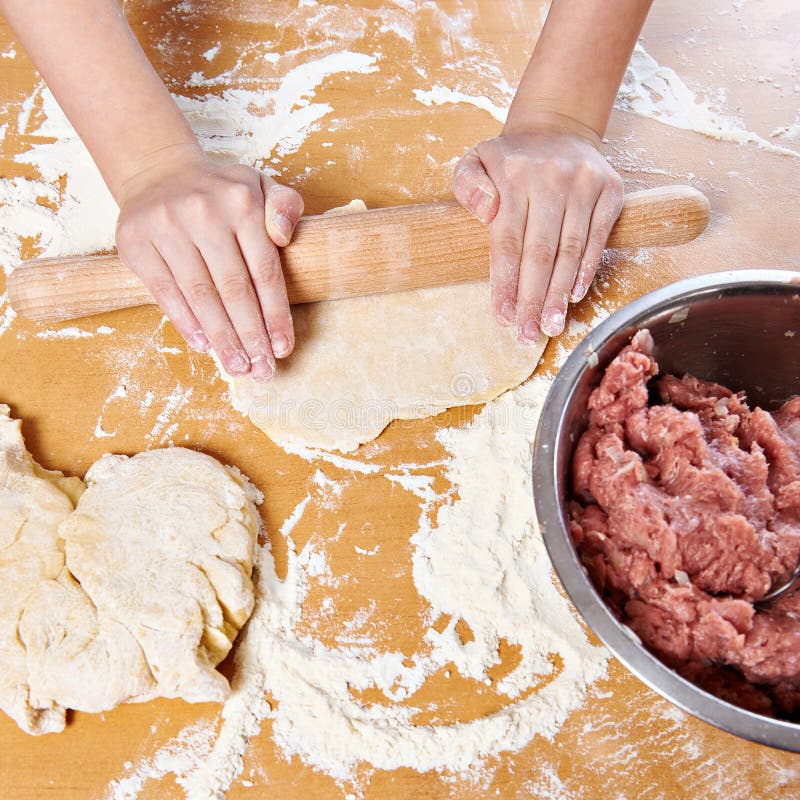 Girl Prepare Dough with Rolling Pin on Kitchen Table Stock Photo