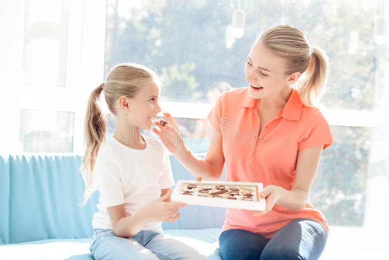 The girl prepared a surprise for her mother. Daughter gave mother a box of chocolates.