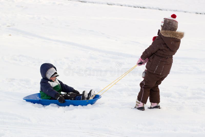 Zwei,, der schnee, ziehen junge auf der Schlitten schlitten.