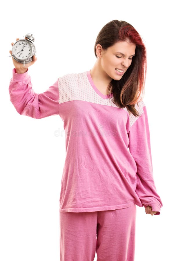 Angry girl in pajamas throwing an alarm clock