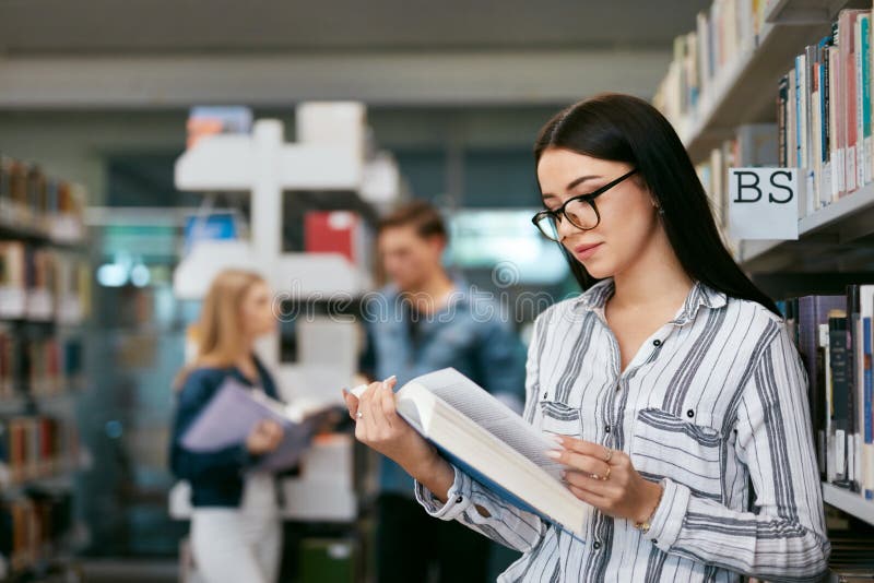 Girl Reading Book In Library. Student Learning royalty free stock images